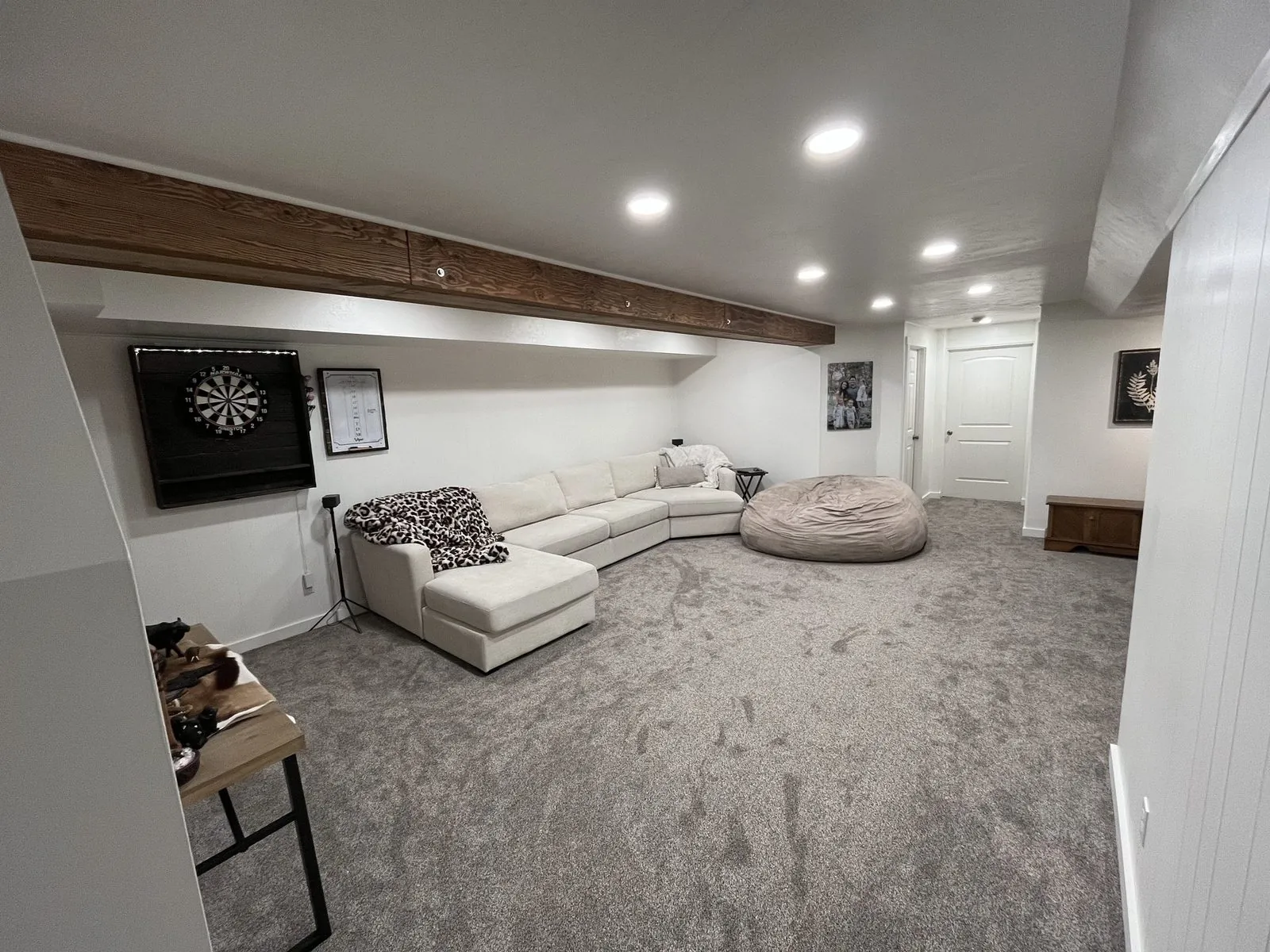 Finished basement rec room — carpet, recessed lighting, wood beam